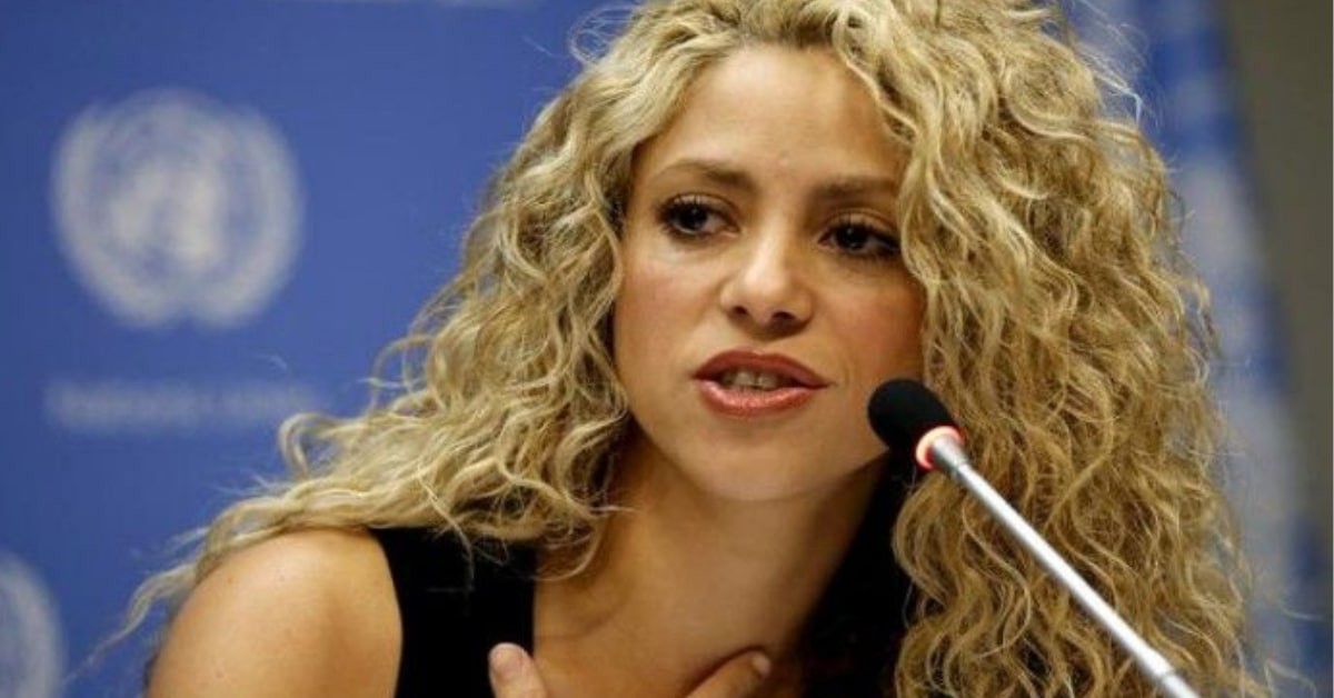 Shakira speaking on a mic