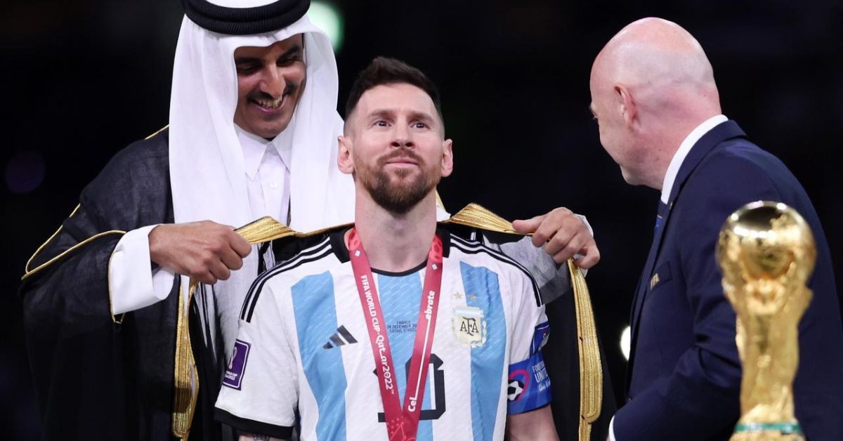 The Emir of Qatar and FIFA President Gianni Infantino puts on a black robe on Lionel Messi